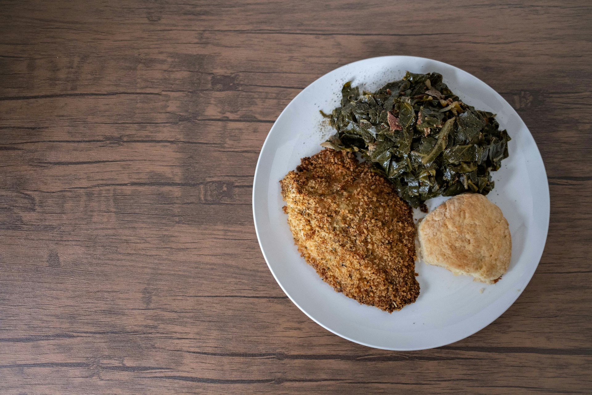 Plate with catfish collard greens and biscuit